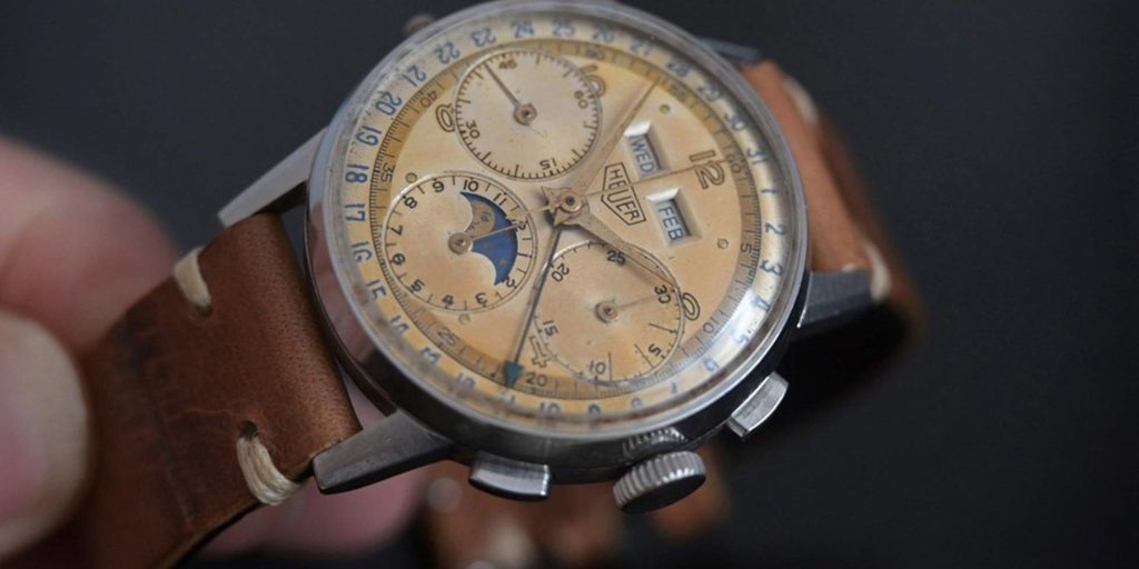 Ancienne montre heuer avec patine typique concentrée autour des index